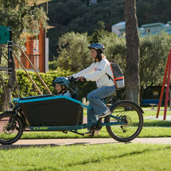Een vrouw in de city met kind op een elektrische transportfiets van CUBE