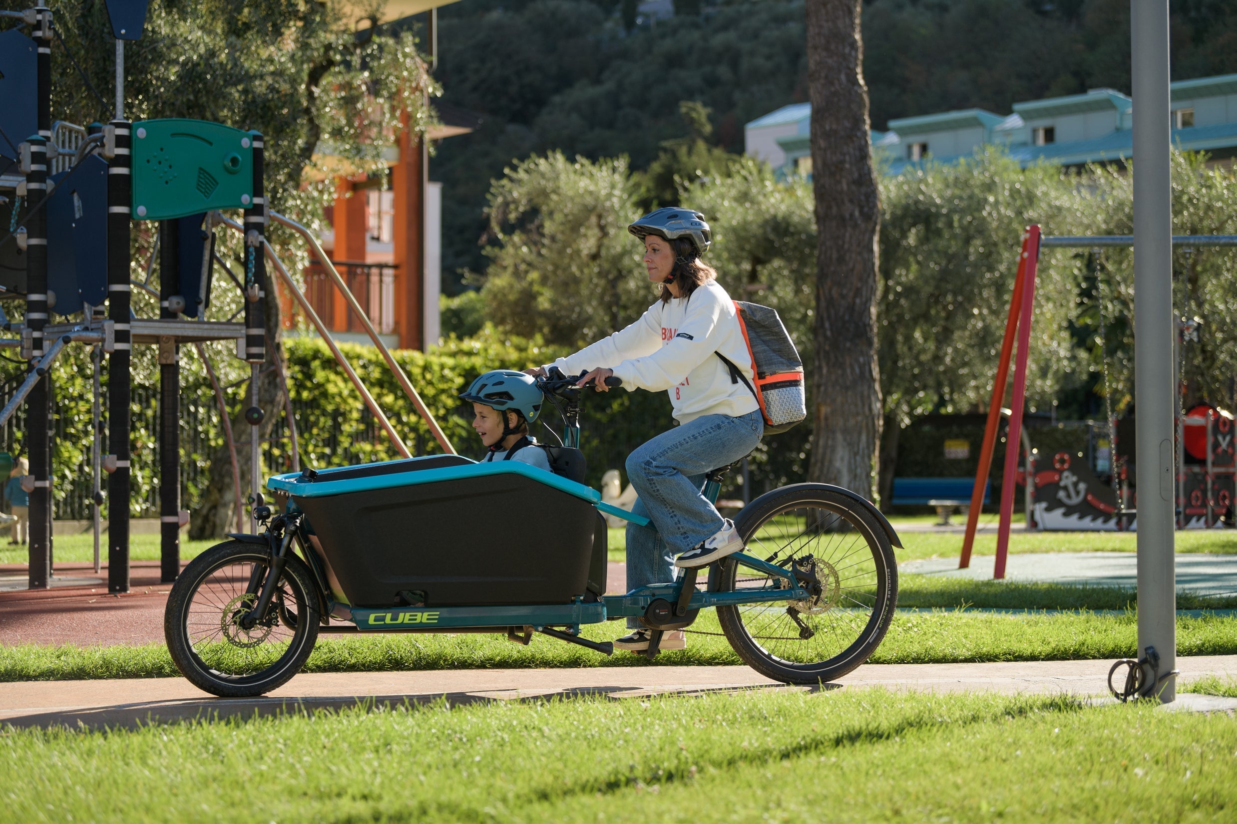 Een vrouw in de city met kind op een elektrische transportfiets van CUBE