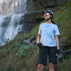 vrouw in een blauw fietsshirt dames voor een waterval